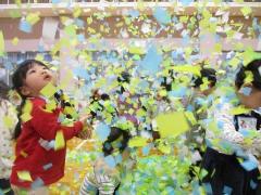 紙吹雪をうちわで舞い上がらせ、キラキラ輝く海の中で遊んでいます。