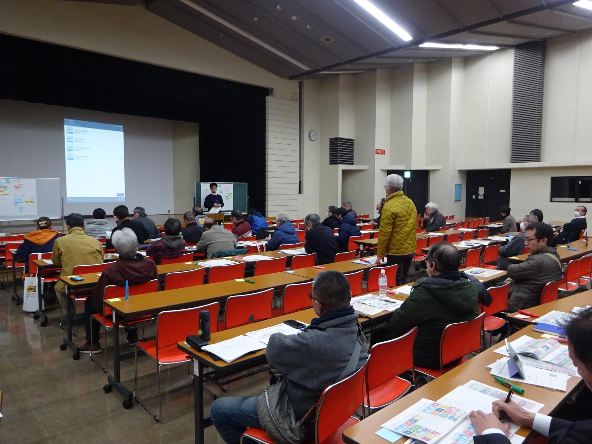 結ネット情報交換会サロングループBと書かれた看板の置かれた部屋の中で話し合いをしている人たちの写真