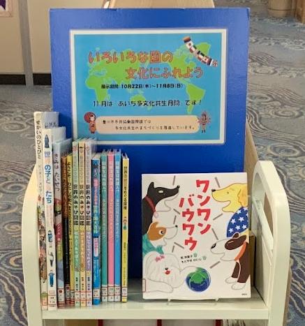 いろいろな国の文化にふれようと書かれた青い板の前に外国関係の本が置かれた本棚の写真