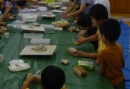 緑色のシートの上で工作をしている子供たちの写真