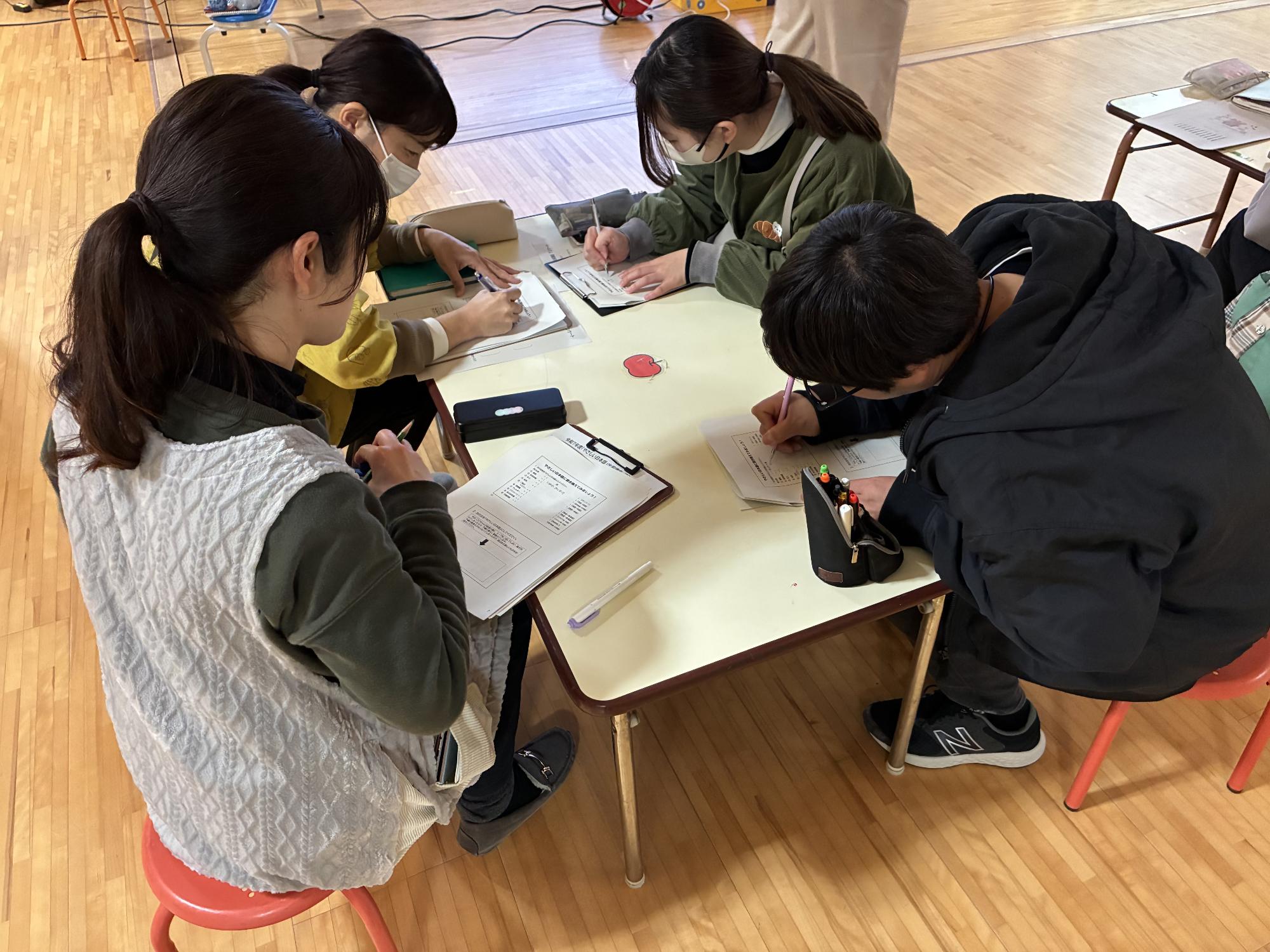 4人の保育士が机で練習問題に取り組んでいる様子