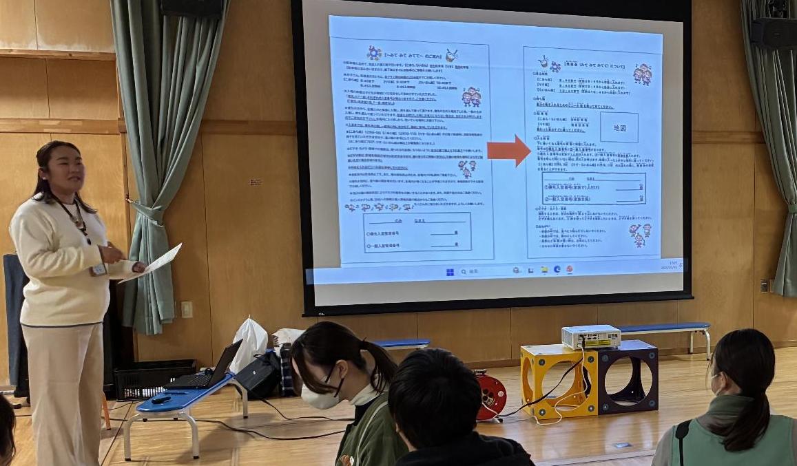 女性が、座っている保育士の前で説明している写真