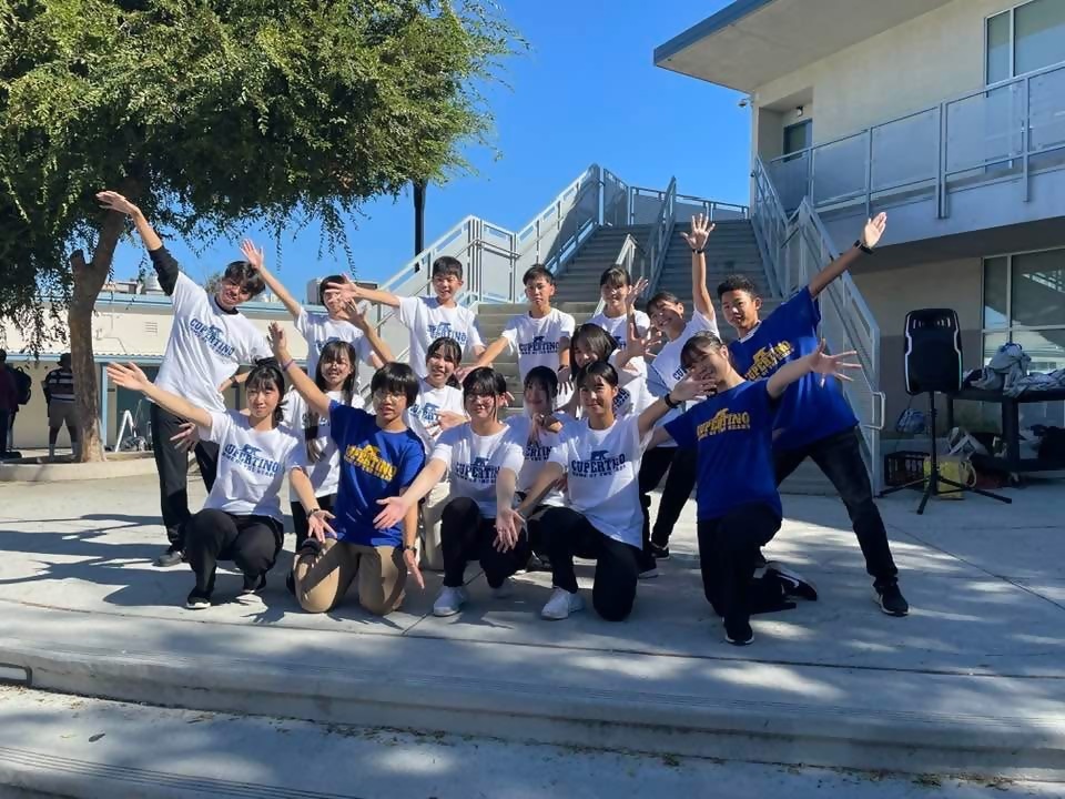 青い服と白い服を着た人達が決めポーズをしている写真