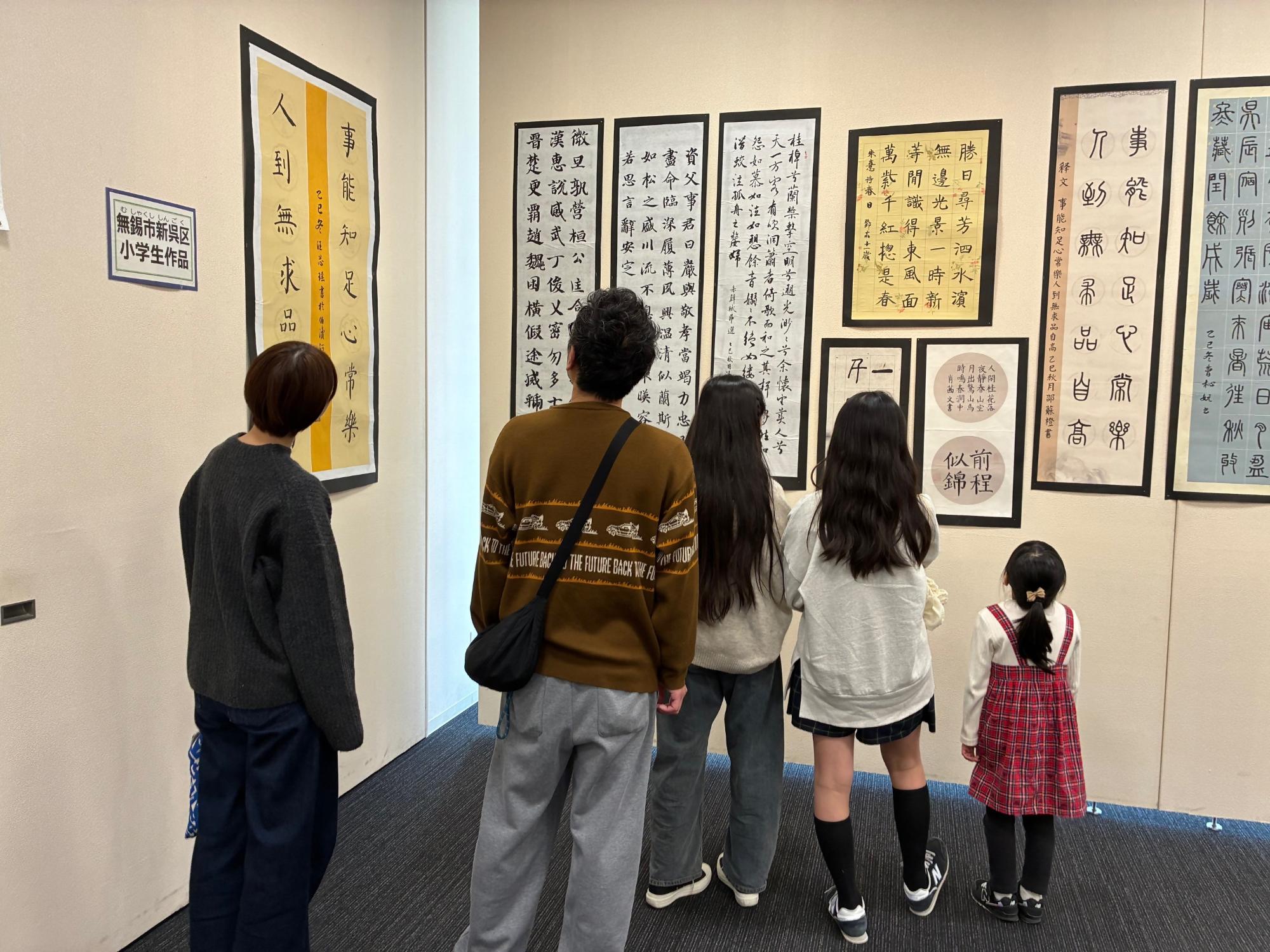 無錫市新呉区の小学生がかいた習字と絵を鑑賞している様子