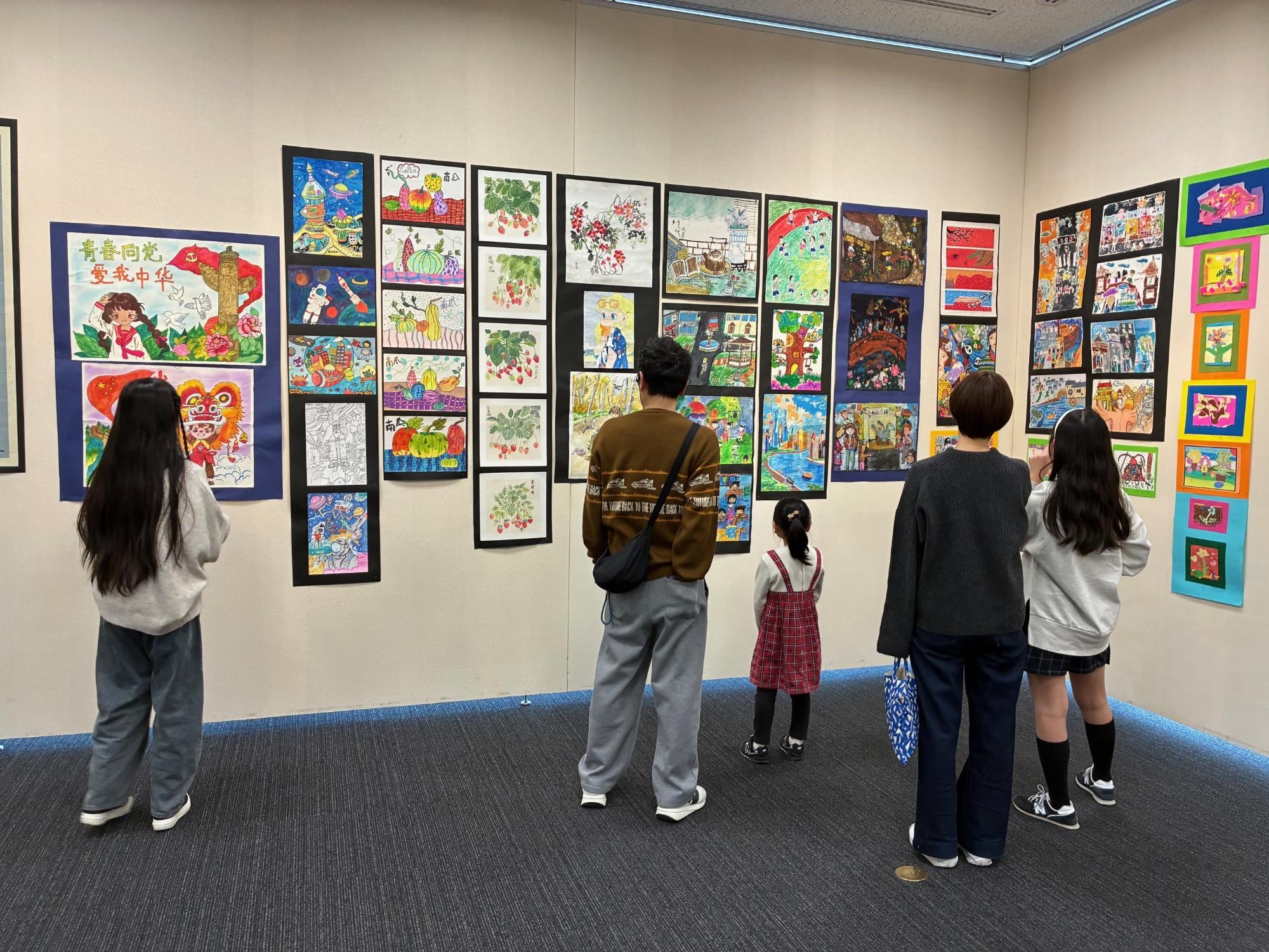 無錫市新呉区の小学生がかいた習字と絵を鑑賞している様子