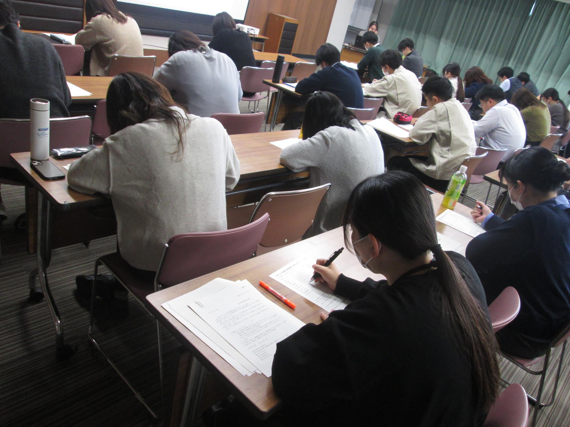 それぞれの長机に座った人が練習問題に取り組んでいる写真