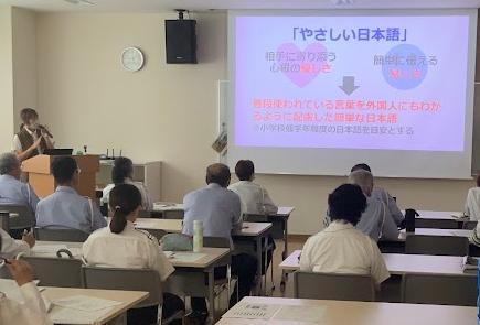 パワーポイントを使って講師が「やさしい日本語」について説明している写真