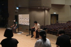 カホンに座りながら話をする人の写真