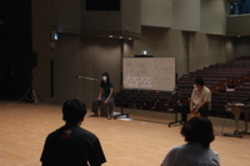 ホワイトボードの両隣に座った人たちとそれを見ている人たちの写真