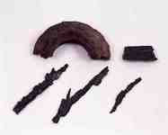 半円の錆びた物や棒状の錆びた物が複数並べられた写真