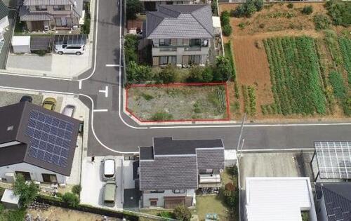住宅と畑の隣にある横長の雑草地が赤い線で囲われている写真