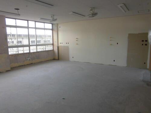 2023年11月時点での三蔵子小学校の天井の蛍光灯と吊り下げ扇風機以外何もない教室内の写真