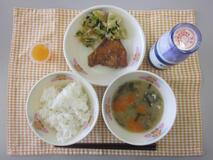 テーブルクロスに並べられたごはん・牛乳・ぶりの竜田揚げ・こまつなの和風あえ・ミニゼリー（蒲郡みかん）の写真