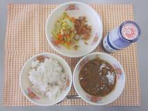 テーブルクロスに並べられた麦ごはん・牛乳・米粉のチキンカレーライス・やさいソテー・福神漬の写真