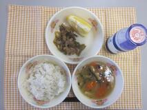テーブルクロスに並べられた麦ごはん・牛乳・じゃがいもだんご汁・ぶた肉丼・あまなつみかんの写真