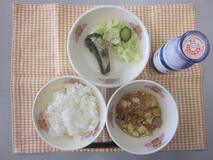 テーブルクロスに並べられたごはん・牛乳・肉どうふ・いわしのしょうが煮・しんこあえの写真