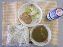 テーブルクロスに並べられたソフトめん・牛乳・米粉のカレーソース・ハムステーキ・コールスローサラダ・コールスロードレッシングの写真