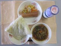 テーブルクロスに並べられた中華めん・牛乳・五目ラーメン・はるまき・中華炒めの写真