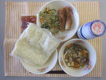 テーブルクロスに並べられた冷やし白玉うどん・牛乳・肉どうふ・ちくわのいそべ揚げ・もやし炒め・うどんつゆの写真