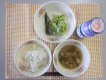 テーブルクロスに並べられたごはん・牛乳・ふ玉汁・いわしのしょうが煮・青菜あえの写真