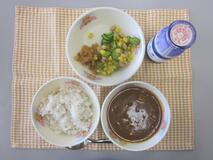テーブルクロスに並べられた麦ごはん・牛乳・米粉のハヤシライス・夏やさいと大豆のサラダ・福神漬の写真
