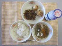 テーブルクロスに並べられた麦ごはん・牛乳・うずらたまごスープ・ビビンバ・ショウロンポウの写真