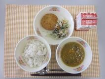 テーブルクロスに並べられた麦ごはん・牛乳・とうがんのカレースープ・さといもコロッケ・三色炒めの写真