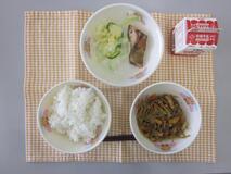 テーブルクロスに並べられたごはん・牛乳・細切りやさいの炒め煮・さけの塩焼き・やさいサラダの写真