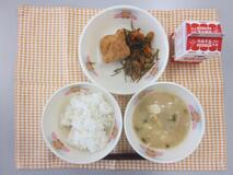 テーブルクロスに並べられたごはん・牛乳・白みそ汁・とり肉の風味揚げ・糸切りこんぶの煮付けの写真