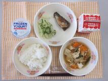 テーブルクロスに並べられたごはん・牛乳・ゆばのすいもの・いわしのうめ煮・青菜あえ・フローズンヨーグルトの写真
