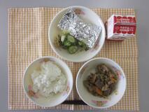 テーブルクロスに並べられたごはん・牛乳・いりどり・さばの銀紙焼き・きゅうりの塩こんぶあえの写真