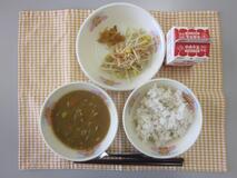 テーブルクロスに並べられた麦ごはん・牛乳・米粉のチキンカレーライス・ごぼうサラダ・福神漬の写真