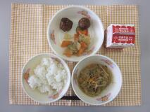 テーブルクロスに並べられたごはん・牛乳・はるさめの炒め煮・肉だんごのあま酢あんかけ・だいこんときゅうりのあえものの写真