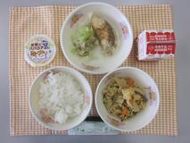 テーブルクロスに並べられたごはん・牛乳・生揚げのたまごとじ・米粉のほきフライ・ボイルキャベツ・お米のみかんババロアの写真