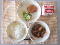 テーブルクロスに並べられたごはん・牛乳・煮みそ・ひれカツ・和風サラダの写真