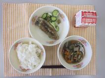 テーブルクロスに並べられたごはん・牛乳・五目汁・いわしのかば焼き丼・きゅうりあえの写真