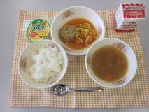 テーブルクロスに並べられたごはん・牛乳・やさいスープ・青じそハンバーグ・カラフルケチャップソテー・かぼちゃプリンの写真