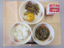 テーブルクロスに並べられたごはん・牛乳・のっぺい汁・大豆と小魚のごまがらめ・みかんの写真