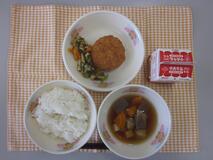 テーブルクロスに並べられたごはん・牛乳・つみれ汁・さつまいもコロッケ・こまつなと油揚げのおかか炒めの写真