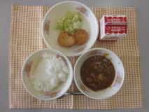 テーブルクロスに並べられたごはん・牛乳・米粉のハヤシライス・愛知の大豆入りナゲット・キャベツソテーの写真