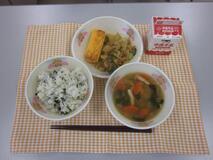 テーブルクロスに並べられたわかめごはん・牛乳・白玉ぞう煮・厚焼きたまご・ごまあえの写真