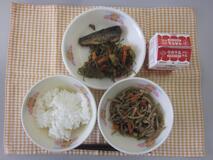 テーブルクロスに並べられたごはん・牛乳・五目きんぴら・いわしのうめ煮・糸切りこんぶの煮付けの写真
