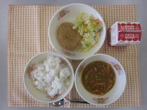 テーブルクロスに並べられた麦ごはん・牛乳・いなりキーマカレー・米粉のコロッケ・コールスローサラダの写真