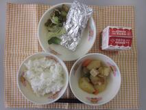 テーブルクロスに並べられたごはん・牛乳・やさいのふくめ煮・さんまの銀紙焼き・きゅうりあえの写真