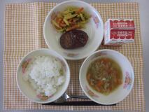 テーブルクロスに並べられたごはん・牛乳・コンソメスープ・ハンバーグのワインソースかけ・カラフル野菜カレーいための写真