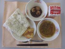 テーブルクロスに並べられたきしめん・牛乳・五目きしめん・にぎすのフライ・ミニぜんざい・パックソースの写真