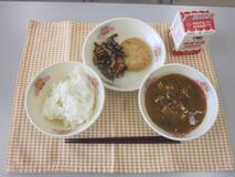 テーブルクロスに並べられたごはん・牛乳・なめこ汁・さけメンチカツ・ひじきの煮付けの写真