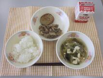 テーブルクロスに並べられたごはん・牛乳・わかめスープ・あじ入りさんが焼き・ピリ辛丼の写真