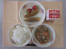 テーブルクロスに並べられたごはん・牛乳・ツナと大豆の煮付け・ちくわのいそべ揚げ・いちごの写真