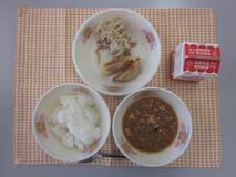 テーブルクロスに並べられたごはん・牛乳・マーボーどうふ・愛知県産食材入りぎょうざ・ボイルもやしの写真